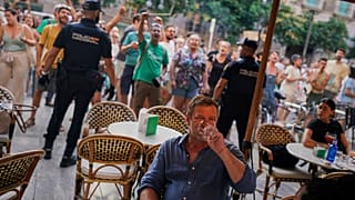 Turistas sentados en un restaurante con terraza durante una protesta contra el turismo excesivo en la isla balear de Mallorca, España, domingo 15 de junio de 2025.