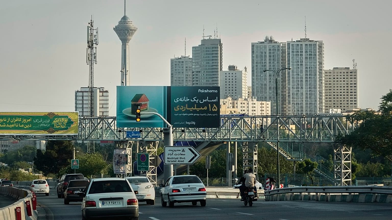مركبات  تسير على طريق سريع مع ظهور أبراج سكنية وبرج ميلاد للاتصالات في الخلفية شمال طهران، إيران، يوم الجمعة 13 يونيو 2025. (صورة أسوشيتد برس/وحيد سليمي)