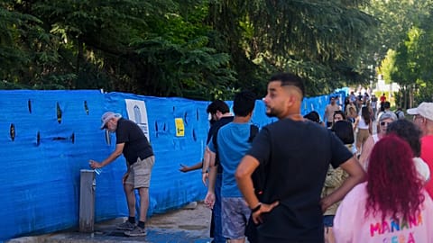 Persone in coda per riempire le bottiglie d'acqua da un rubinetto pubblico a Madrid, Spagna, 19 luglio 2024.