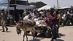 فلسطينيون يحملون حقائب تحتوي على طرود مساعدات غذائية وإنسانية سلمتها مؤسسة غزة الإنسانية، وهي منظمة مدعومة من الولايات المتحدة، في رفح، جنوب قطاع غزة، الاثنين، 16 يونيو 2025.