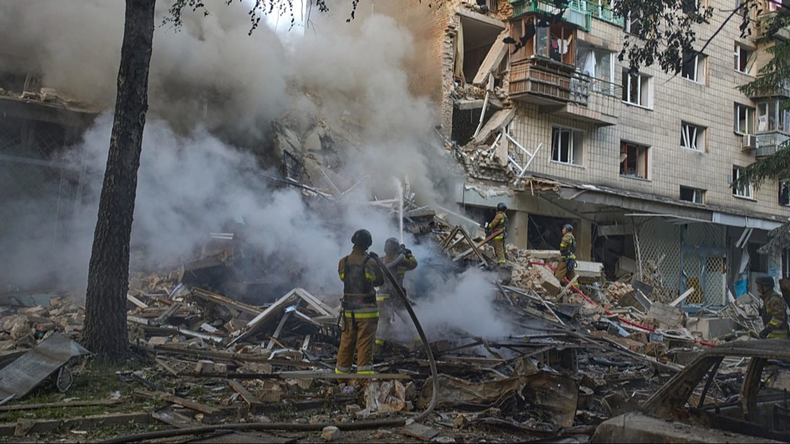 Os bombeiros apagam o fogo depois de um míssil russo ter atingido um edifício residencial durante o ataque aéreo maciço de mísseis e drones da Rússia em Kiev, Ucrânia, terça-feira, 17 de junho de 2025