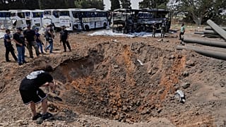 Israeli security forces inspect a site hit by a missile launched from Iran in central Israel, 17 June, 2025