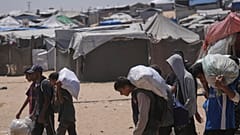 فلسطينيون يحملون أكياسًا تحتوي على مساعدات غذائية وإنسانية وزّعتها "مؤسسة غزة الإنسانية" المدعومة من الولايات المتحدة، في رفح جنوب قطاع غزة، يوم الاثنين 16 حزيران/يونيو 2025.