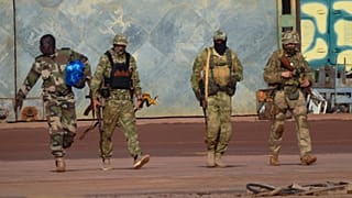Esta fotografia sem data, distribuída pelo exército francês, mostra três mercenários russos, à direita, no norte do Mali.