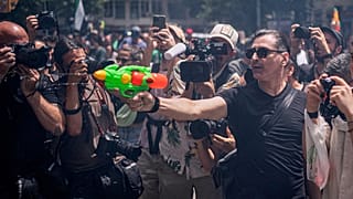 Un manifestante impugna una pistola ad acqua durante una protesta contro l'eccessivo turismo a Barcellona, in Spagna.