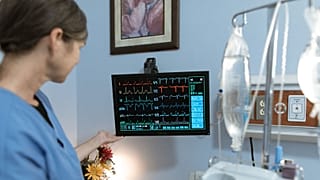A nurse looks at a monitor.