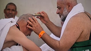 يحلق حاج مسلم رأسه، وهو جزء مهم من طقوس العمرة والحج في الإسلام، أثناء رمي الجمرات الرمزي، السعودية، الجمعة 6 يونيو 2025.  