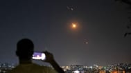 رجل يلتقط صورة لهاتف محمول بينما صواريخ تطلق من إيران باتجاه إسرائيل تحلق فوق الأراضي السورية في دمشق ، سوريا ، في وقت مبكر من يوم الأربعاء ، 18 يونيو ، 2025