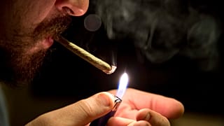 2013 yılına ait bu dosya fotoğrafında bir adam Meksika'daki evinde marihuana içiyor.