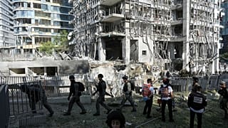 Kurtarma görevlileri ve askeri personel, 19 Haziran 2025 Perşembe günü İsrail'in Ramat Gan kentinde İran'dan atılan bir füzenin doğrudan isabet ettiği bölgeyi inceliyor.