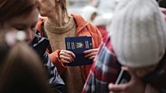 Μια γυναίκα κρατάει ουκρανικά διαβατήρια καθώς περιμένει να εγγραφεί σε λεωφορείο που θα μεταφέρει πρόσφυγες στη Γερμανία, στο σιδηροδρομικό σταθμό του Przemysl, Πολωνία, Πέμπτη 3 Μαρτίου 2022. 