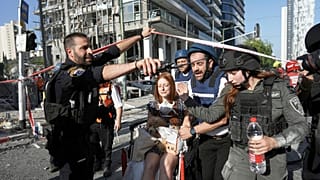 امرأة يتم إجلاؤها من موقع إصابة مباشرة من ضربة صاروخية إيرانية في رمات غان، إسرائيل، الخميس، 19 يونيو 2025.