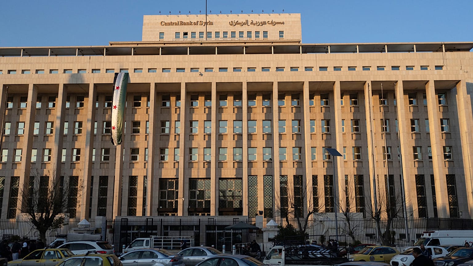 سيارات تسير بجوار البنك المركزي في دمشق، سوريا،