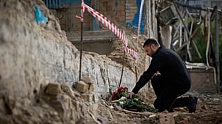 Ukrainian President Volodymyr Zelenskyy lays flowers at the site of Russia's Tuesday deadly missile attack that ruined a multistory residential building in Kyiv, June 19, 2
