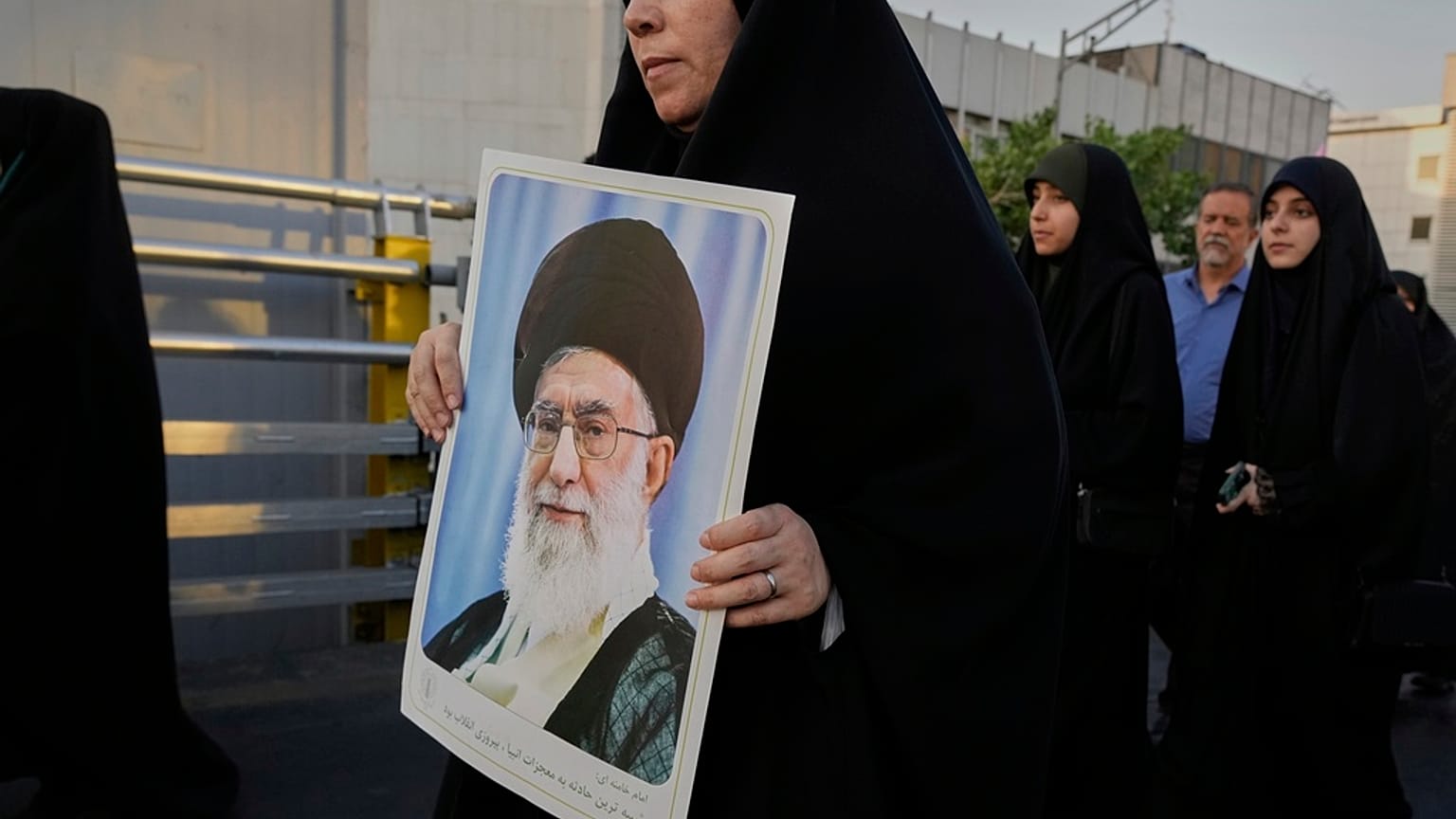 امرأة تحمل ملصقًا للمرشد الأعلى الإيراني آية الله علي خامنئي خلال تجمع حاشد بمناسبة عيد الغدير الشيعي الإسلامي