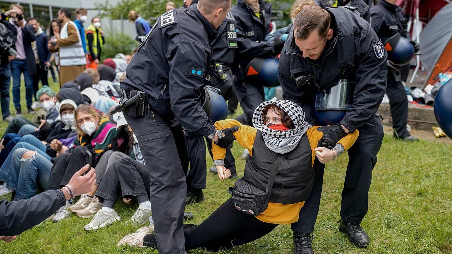 Uma mulher é levada por agentes da polícia durante uma manifestação pró-palestinianos do grupo "Student Coalition Berlin" . 