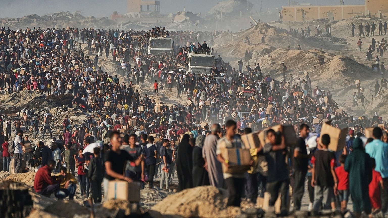 Palästinenser tragen Säcke und Kisten mit Lebensmitteln und humanitärer Hilfe, die von einem Konvoi des Welternährungsprogramms abgeladen wurden.