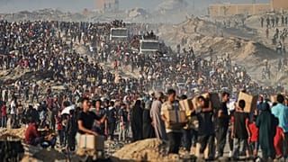 Varios palestinos transportan cajas de ayuda humanitaria descargadas de un convoy del Programa Mundial de Alimentos.