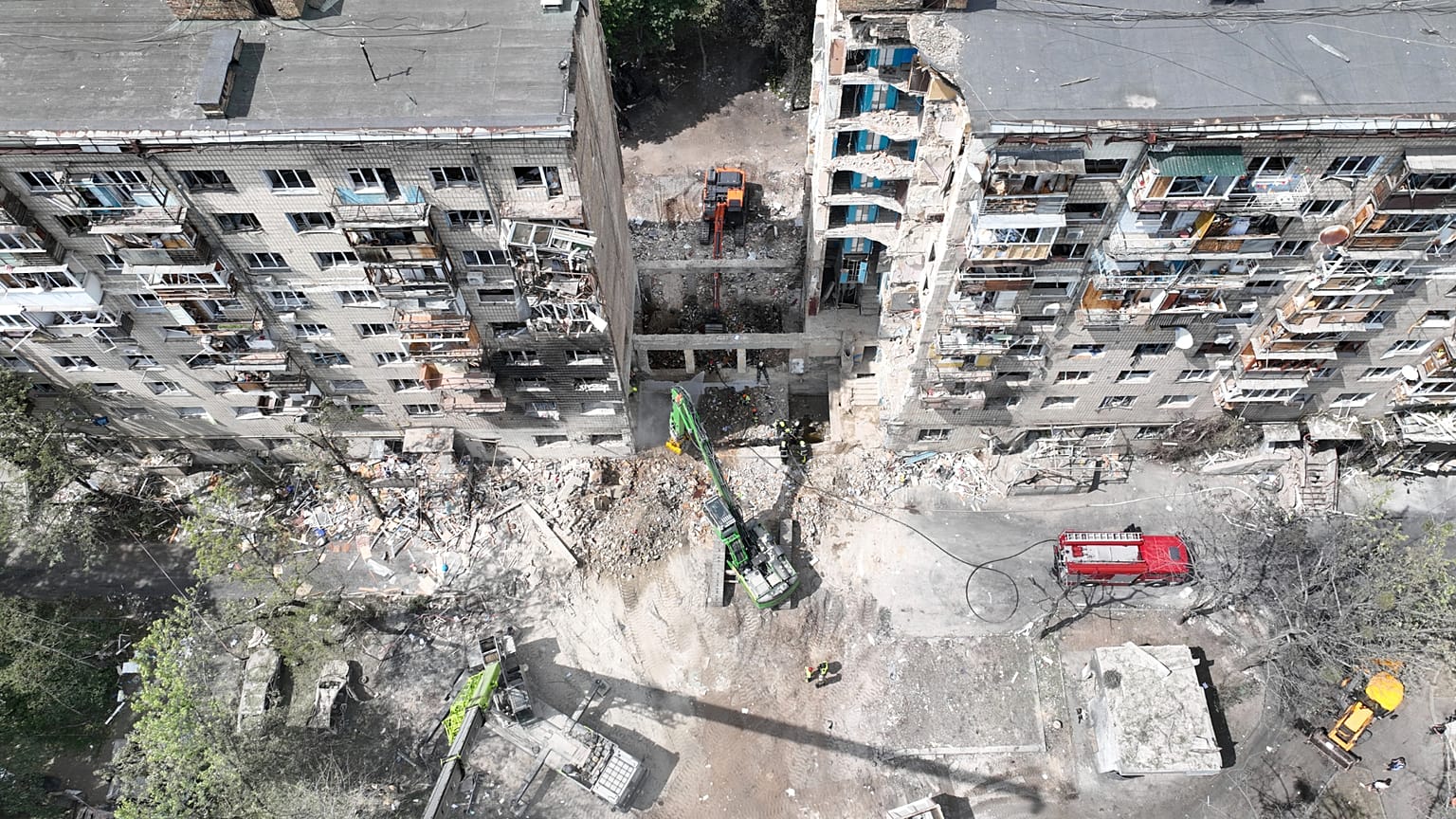 Equipas de salvamento vasculham os destroços no local do ataque russo com mísseis que destruiu um edifício residencial em Kiev, a 18 de junho de 2025