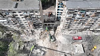 Equipas de salvamento vasculham os destroços no local do ataque russo com mísseis que destruiu um edifício residencial em Kiev, a 18 de junho de 2025