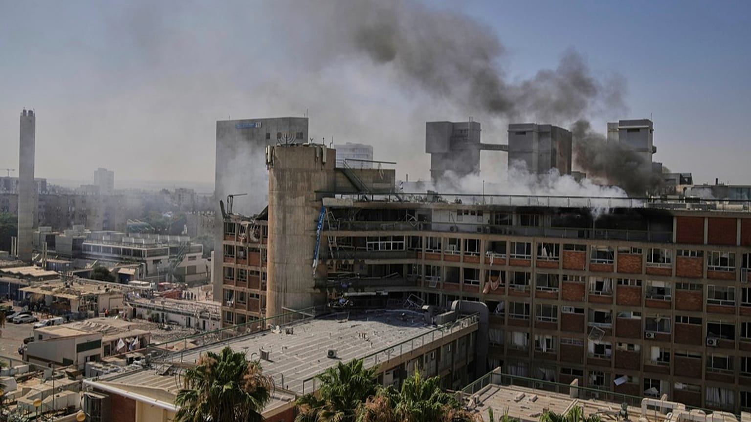 İsrail'in Beerşeba kentinde İran'dan atılan bir füzenin isabet ettiği Soroka hastane kompleksinin bir binasından dumanlar yükseliyor, 19 Haziran 2025, Perşembe.