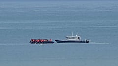 FILE - A boat thought to carry migrants is escorted by a vessel from the French Gendarmerie Nationale in the English Channel, 4 September 2024.