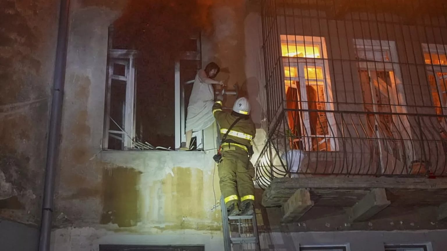 Na zdjęciu udostępnionym przez ukraińską służbę ratunkową strażacy ewakuują mieszkańca z płonącego budynku mieszkalnego po zmasowanym rosyjskim ataku powietrznym w Odessie.