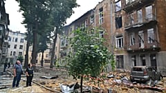 Des personnes observent un immeuble d'habitation incendié à la suite d'une attaque aérienne massive de la Russie à Odessa, en Ukraine, le vendredi 20 juin 2025 ;