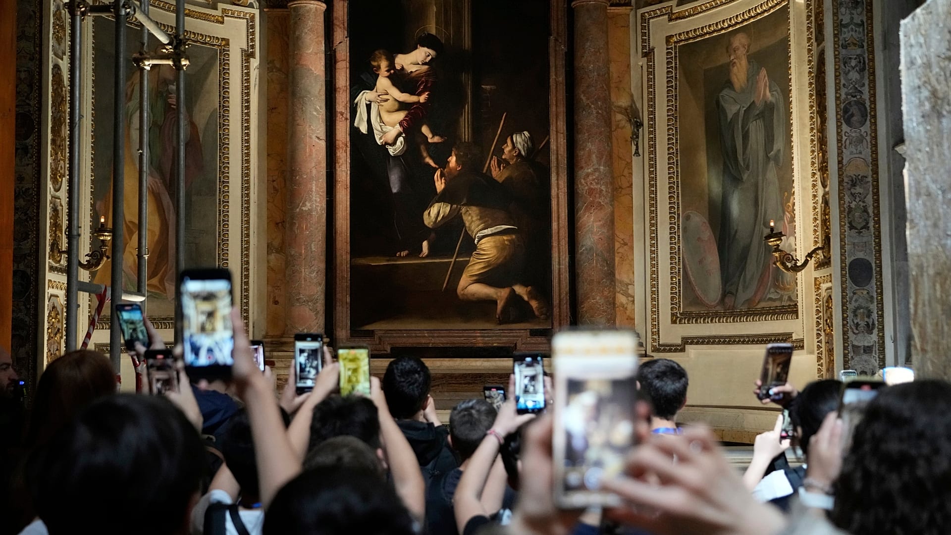 Turistas admiran la Virgen de los Peregrinos, de Caravaggio, en la Basílica de San Agustín de Roma.