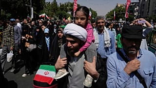 A cleric carries a small child on his shoulder during a demonstration to denounce Israeli attacks on several cities across Iran, after Friday prayers in Tehran, Iran, Friday, 20 June 2025