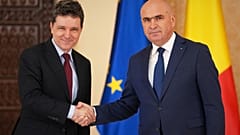 Ο πρόεδρος της Ρουμανίας Nicusor Dan, αριστερά, σφίγγει το χέρι στον Ilie Bolojan, πρόεδρο της Γερουσίας της χώρας, μετά τον διορισμό του ως νέου πρωθυπουργού 