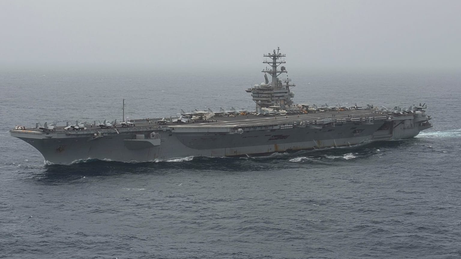 Az amerikai haditengerészet által közzétett képen a USS Nimitz repülőgép-hordozó az Arab-tengeren halad át 2020. augusztus 17-én.  