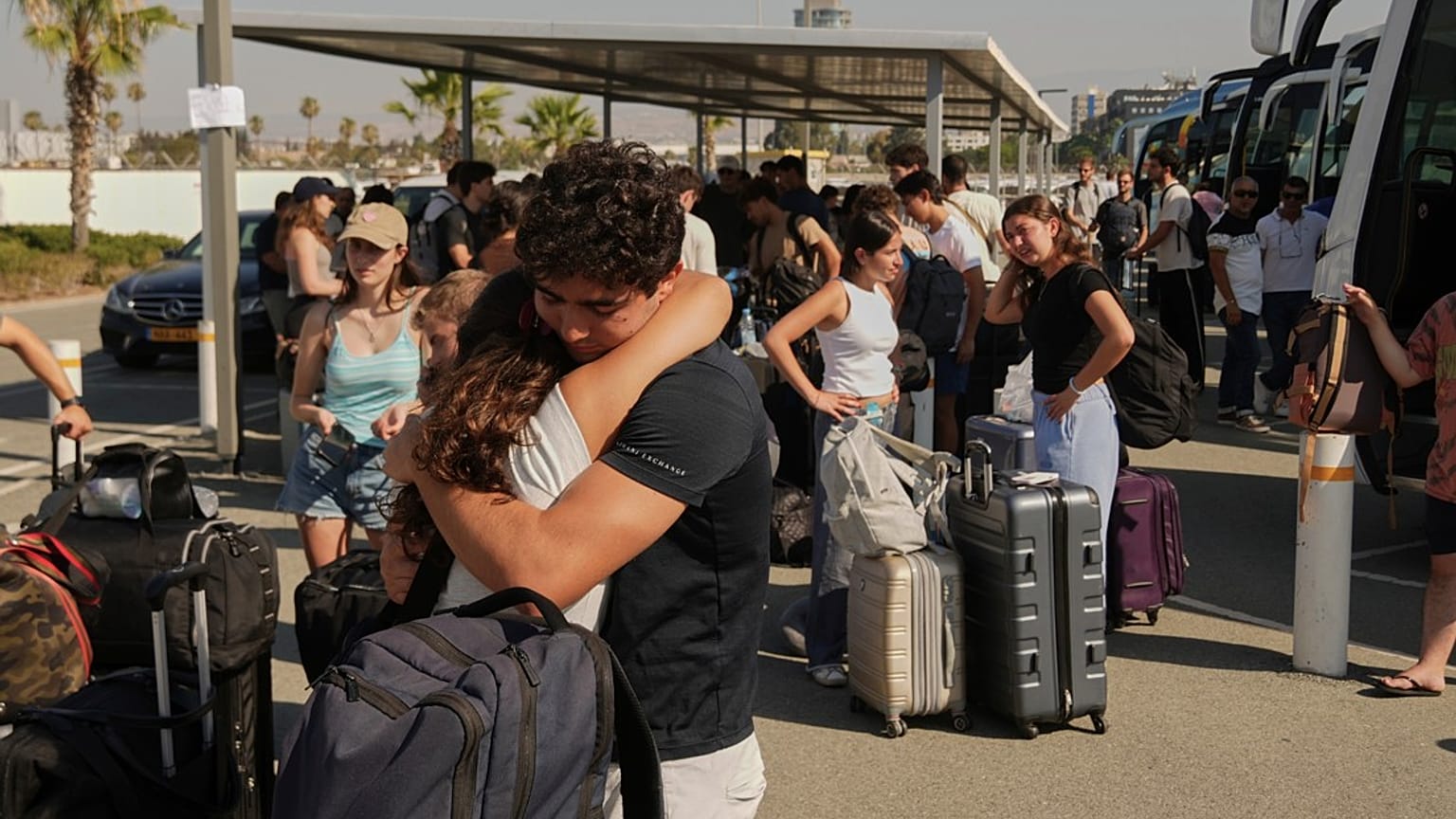 يحتضن النازحون من إسرائيل بعضهم البعض لدى وصولهم إلى ميناء ليماسول الرئيسي في قبرص، يوم السبت 21 يونيو/حزيران 2025.