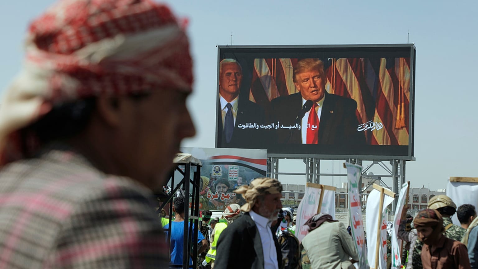 Húti támogatók jelszavakat skandálnak egy Donald Trumpot bíráló transzparens alatt tartott USA- és Izrael-ellenes tüntetésen a jemeni Szanaában, 2025. május 16-án