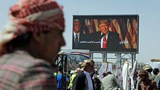 Húti támogatók jelszavakat skandálnak egy Donald Trumpot bíráló transzparens alatt tartott USA- és Izrael-ellenes tüntetésen a jemeni Szanaában, 2025. május 16-án