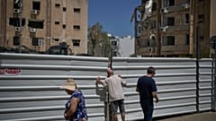 Bir adam, İran füzesinin Tel Aviv yakınlarındaki Holon’da bir yerleşim alanına düşmesinden bir gün sonra çitin üzerinden bakıyor, 20 Haziran 2025.
