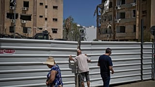 Bir adam, İran füzesinin Tel Aviv yakınlarındaki Holon’da bir yerleşim alanına düşmesinden bir gün sonra çitin üzerinden bakıyor, 20 Haziran 2025.