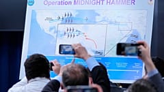 Reporters take photos of a displayed graphic as Defense Secretary Pete Hegseth speak during a news conference at the Pentagon  in Washington, Sunday, June 22, 2025.