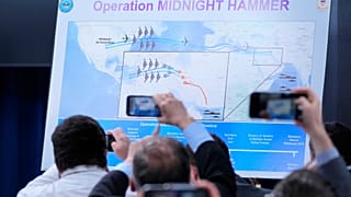 Reporters take photos of a displayed graphic as Defense Secretary Pete Hegseth speak during a news conference at the Pentagon in Washington, Sunday, June 22, 2025.