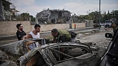 Rettungskräfte und Feuerwehrleute begutachten den Ort eines direkten Raketeneinschlags aus dem Iran in Ness Ziona, Israel, Sonntag, 22. Juni 2025.