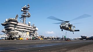 Egy MH-60S Sea Hawk helikopter lebeg a USS Carl Vinson repülőgép-hordozó felett, miközben a Közel-Keleten tevékenykedik 2025. április 12-én.