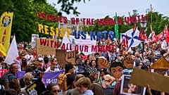 Menschen halten Transparente während einer Demonstration vor dem NATO-Gipfel in Den Haag, Niederlande, Sonntag, 22. Juni 2025