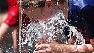 Jude Puroway se refresca en una fuente cuando hace calor en Chicago.
