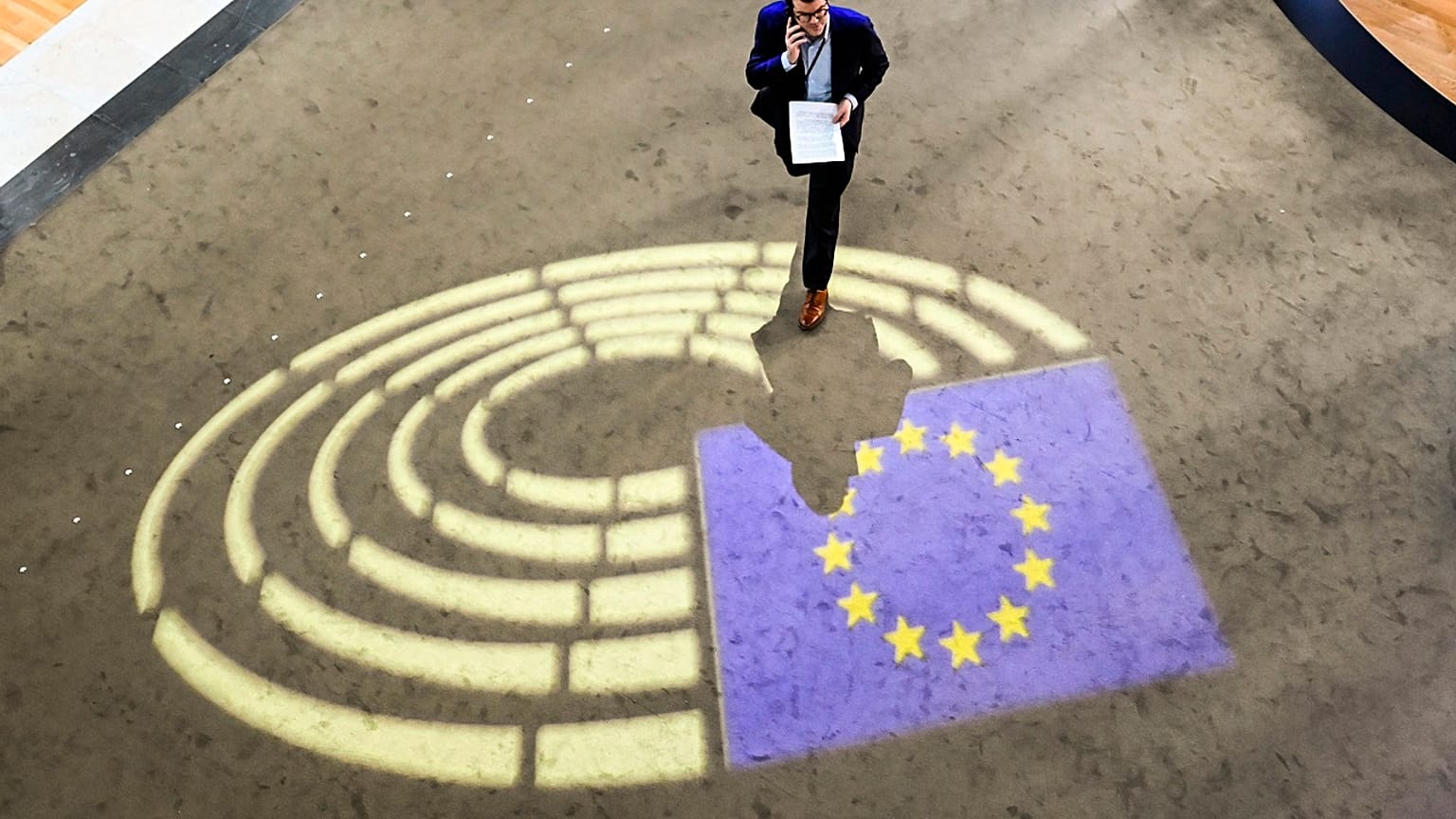 A man walks inside the European Parliament.