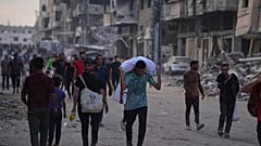 فلسطينيون يحملون أكياسا غذائية ومساعدات إنسانية تم تفريغها من قافلة شاحنات كانت متوجهة إلى مدينة غزة ، شمال قطاع غزة ، الأحد 22 حزيران / يونيو 2025.