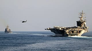 Авианосец USS Dwight D. Eisenhower и другие военные корабли пересекают Ормузский пролив в Персидском заливе в воскресенье, 26 ноября 2023 года.