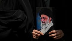 متظاهر يحمل ملصقًا للمرشد الأعلى الإيراني آية الله علي خامنئي، إيران، الجمعة 20 يونيو 2025.  