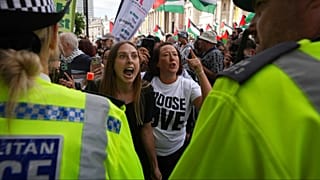 Dimostranti gridano e gesticolano verso una linea di polizia durante una protesta del gruppo Palestine Action a Londra, lunedì 23 giugno 2025.