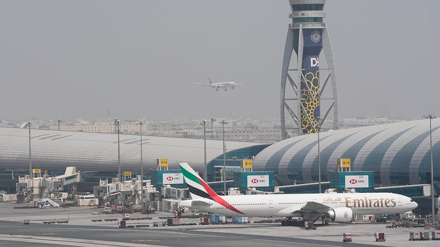 Bir Emirates Boeing 777'si Dubai Uluslararası Havalimanı'nda kapıda duruyor.
