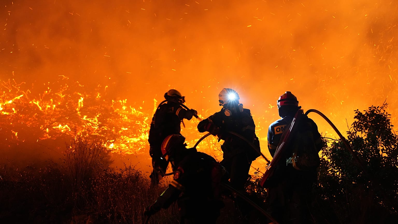 Firefighters battle with a large wildfire burning in Kofinas on the eastern Aegean island of Chios, 22 June, 2025